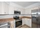 Updated kitchen with stainless steel appliances, wood look countertops, and crisp white cabinets at 7977 W Wacker Rd # 174, Peoria, AZ 85381