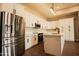 Modern kitchen features white cabinets, quartz countertops, a large stainless refrigerator, and black hardware and fixtures at 20618 W Elliot Rd, Buckeye, AZ 85326
