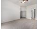 Bedroom features neutral carpet, a ceiling fan, and doorways leading to closet and en-suite bathroom at 26 S Quinn Cir # 7, Mesa, AZ 85206