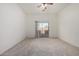 Spacious bedroom featuring neutral carpet, a ceiling fan, and sliding glass door leading to the outdoor space at 26 S Quinn Cir # 7, Mesa, AZ 85206
