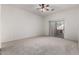 Spacious bedroom featuring neutral carpet, a ceiling fan, and sliding glass door leading to the outdoor space at 26 S Quinn Cir # 7, Mesa, AZ 85206