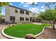 Large backyard features a lush lawn, stone landscaping, a brick patio, mature trees, and a two-story home at 1392 E Baker Dr, San Tan Valley, AZ 85140