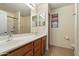 Bathroom with double sinks, wood cabinetry, large mirrors, and a shower over tub at 1392 E Baker Dr, San Tan Valley, AZ 85140