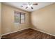 Cozy bedroom with natural light from a window and hardwood floors complemented by a ceiling fan at 1392 E Baker Dr, San Tan Valley, AZ 85140