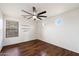 Clean bedroom with wood-look floors, shelving, neutral walls, and bright windows at 1392 E Baker Dr, San Tan Valley, AZ 85140