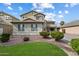 View of the front exterior showing desert landscaping, shrubbery, and a glimpse of the surrounding neighborhood at 1392 E Baker Dr, San Tan Valley, AZ 85140