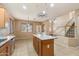Spacious kitchen featuring a large island, stainless steel appliances, tile flooring, and seamless transition to living and dining areas at 1392 E Baker Dr, San Tan Valley, AZ 85140