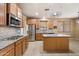 Modern kitchen featuring stainless steel appliances, granite countertops, a kitchen island, and stylish lighting fixtures, ready for cooking at 1392 E Baker Dr, San Tan Valley, AZ 85140