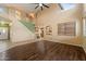 Open-concept living area featuring a staircase, hardwood flooring, high ceilings, and a view into the adjacent kitchen and dining space at 1392 E Baker Dr, San Tan Valley, AZ 85140