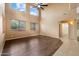 Bright living room with soaring ceilings, hardwood flooring, large windows, and a modern ceiling fan, perfect for entertaining guests at 1392 E Baker Dr, San Tan Valley, AZ 85140