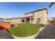 Well-maintained backyard with manicured artificial grass, outdoor kitchen, and covered patio area at 272 N 167Th Ln, Goodyear, AZ 85338