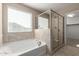 Bathroom features a soaking tub, glass enclosed shower, and modern fixtures at 272 N 167Th Ln, Goodyear, AZ 85338