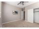 Cozy bedroom showcasing a mounted television and a sliding-door closet, maximizing space at 272 N 167Th Ln, Goodyear, AZ 85338