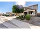 Charming home exterior with a well-manicured front yard and mature shade tree at 272 N 167Th Ln, Goodyear, AZ 85338