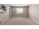 Empty living room offering neutral walls, carpet, and a window for natural light at 272 N 167Th Ln, Goodyear, AZ 85338