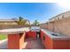 Outdoor kitchen featuring a built-in grill, bar seating, and sink, perfect for outdoor entertaining at 272 N 167Th Ln, Goodyear, AZ 85338
