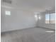 Bright bedroom with large windows and grey carpeting at 18424 W Monte Lindo Ln, Surprise, AZ 85387