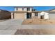 Two-story house with tan exterior, teal door, and landscaped yard at 18424 W Monte Lindo Ln, Surprise, AZ 85387