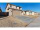 Two-story house with tan exterior, teal door, and landscaped yard at 18424 W Monte Lindo Ln, Surprise, AZ 85387
