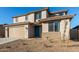 Two-story house with tan exterior, teal door, and landscaped yard at 18424 W Monte Lindo Ln, Surprise, AZ 85387
