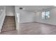 Spacious living room with wood-look tile floor and stairway at 18424 W Monte Lindo Ln, Surprise, AZ 85387