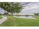 Community lake and clubhouse with green grass, walking path, and shady trees at 22788 E Orion Way, Queen Creek, AZ 85142