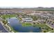 Aerial view of the community pool, clubhouse and lake in a residential neighborhood with mountain views at 22788 E Orion Way, Queen Creek, AZ 85142