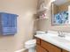 Clean bathroom with single sink vanity, toilet, and decorative shelves at 7156 S Forest Ave, Gilbert, AZ 85298