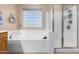 Relaxing bathroom with a soaking tub, shower, and a block window at 7156 S Forest Ave, Gilbert, AZ 85298