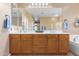 Bathroom with double vanity, wood cabinets and large mirror at 7156 S Forest Ave, Gilbert, AZ 85298