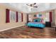 Spacious bedroom with wood floors, large windows, and a comfy bed at 7156 S Forest Ave, Gilbert, AZ 85298