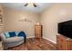 Cozy bedroom featuring a round sofa, wooden dresser, and flat-screen TV at 7156 S Forest Ave, Gilbert, AZ 85298