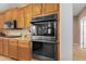 Modern kitchen with double oven, granite countertops, and wood cabinets at 7156 S Forest Ave, Gilbert, AZ 85298