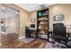 Home office with two desks, built-in shelving, and hardwood floors at 7156 S Forest Ave, Gilbert, AZ 85298