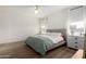 A bedroom with a ceiling fan, wood floor, large windows, and a queen bed at 20025 W Madison St, Buckeye, AZ 85326