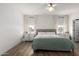This bedroom features two windows, a ceiling fan, and two dressers on either side of the bed at 20025 W Madison St, Buckeye, AZ 85326