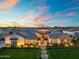 Stunning exterior of a home featuring manicured lawns, elegant landscaping, and a welcoming entrance with beautiful sunset views at 2652 E Pelican Ct, Gilbert, AZ 85297