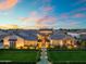 Beautiful exterior showcasing manicured lawns, landscaping, and inviting entrance with a vibrant sunset backdrop at 2652 E Pelican Ct, Gilbert, AZ 85297