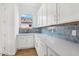 Bright laundry room with white cabinets and blue tile at 22837 E Alyssa Rd, Queen Creek, AZ 85142