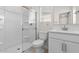 This bathroom features a glass-enclosed shower, a white vanity and toilet and a window at 7453 S 75Th Dr, Laveen, AZ 85339