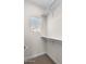 A simple walk-in closet is shown with white walls, carpet, a window and shelving rods at 7453 S 75Th Dr, Laveen, AZ 85339
