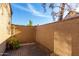 Enclosed backyard patio with wood plank flooring, a stucco wall, rocks, and desert landscaping at 8111 W Wacker Rd # 121, Peoria, AZ 85381