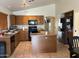 Well-equipped kitchen features ample wooden cabinetry, a functional island, and stainless steel appliances at 12009 W Aster Dr, El Mirage, AZ 85335