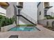 Clean modern backyard pool with steps to balcony, neutral paving, a chaise lounge, and verdant garden at 6914 E 2Nd St, Scottsdale, AZ 85251