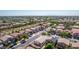 Aerial view of a community with a mountain backdrop, showcasing uniform houses, mature trees, and paved roads at 17552 W Young St, Surprise, AZ 85388