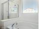 Elegant bathroom featuring a soaking tub with a shower and a large window offering natural light and views at 17552 W Young St, Surprise, AZ 85388