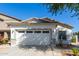 Attached two car garage with a modern door, complimented by fresh landscaping and a convenient driveway at 17552 W Young St, Surprise, AZ 85388