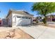 A two-car garage with well-maintained exterior, complemented by a spacious driveway and tasteful landscaping at 17552 W Young St, Surprise, AZ 85388