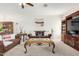 Cozy living room featuring plush carpeting, brown sofas, and decorative wall hangings at 17552 W Young St, Surprise, AZ 85388