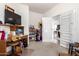 A cluttered living room with a television, a bookcase, and a doorway leading to another room at 17552 W Young St, Surprise, AZ 85388